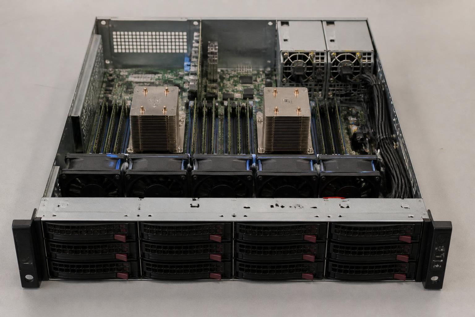 Rack server with the lid removed showing hot swap drive bays, memory, heatsinks and power supplies